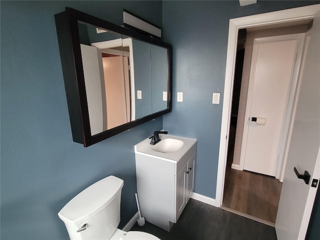 bathroom with vanity, toilet, and hardwood / wood-style floors