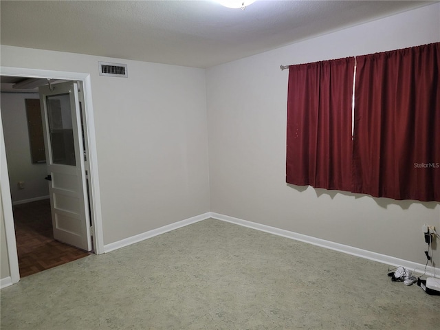 unfurnished room featuring dark colored carpet