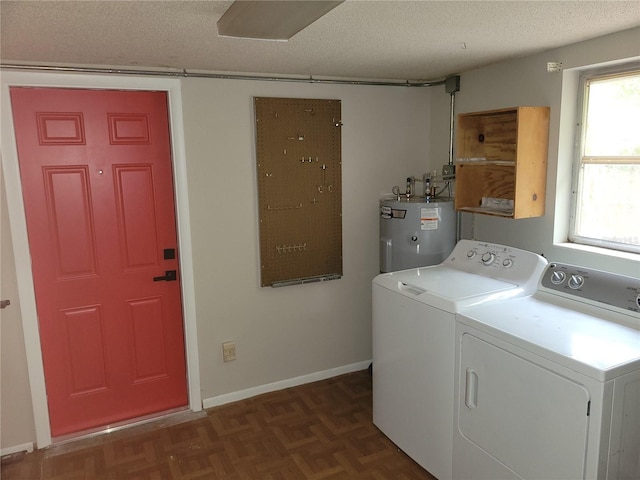 clothes washing area with dark parquet flooring, a textured ceiling, washer and clothes dryer, and water heater