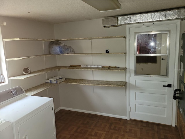 laundry area with dark parquet flooring, a textured ceiling, and washer and clothes dryer