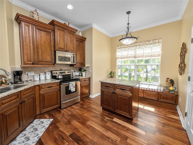 kitchen featuring stainless steel appliances, hanging light fixtures, sink, a center island, and dark hardwood / wood-style floors