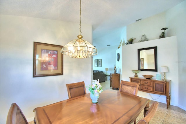 tiled dining area featuring a textured ceiling and an inviting chandelier