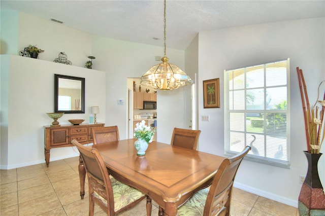 dining area with light tile patterned flooring, a chandelier, and a textured ceiling