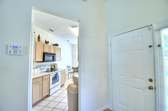 kitchen featuring white electric range oven, light brown cabinets, and light tile patterned flooring