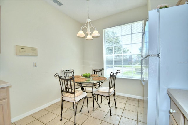 tiled dining area with a healthy amount of sunlight and a chandelier