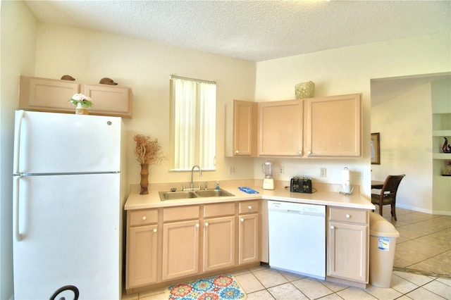 kitchen featuring light brown cabinetry, sink, light tile patterned floors, and white appliances