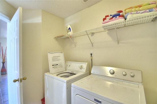 washroom featuring tile patterned flooring, a textured ceiling, and separate washer and dryer