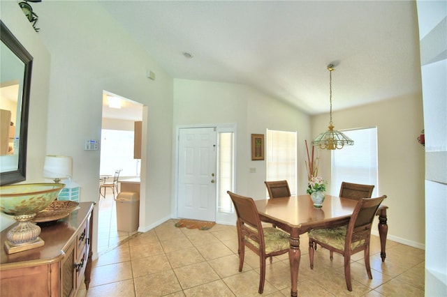 dining space featuring light tile patterned floors and vaulted ceiling