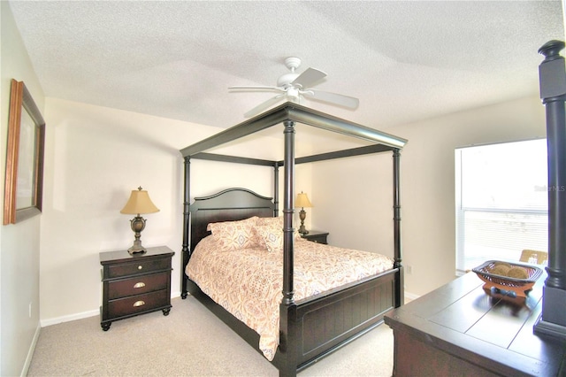 carpeted bedroom featuring ceiling fan and a textured ceiling