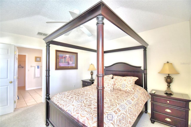 carpeted bedroom with ceiling fan and a textured ceiling