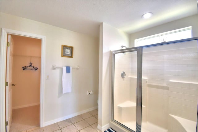 bathroom featuring tile patterned flooring, toilet, and an enclosed shower