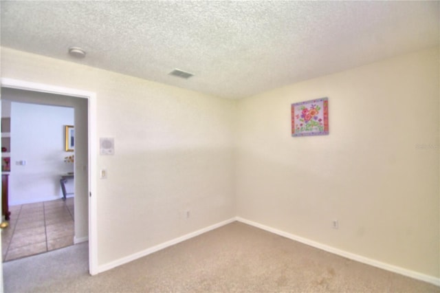 empty room with a textured ceiling and carpet floors