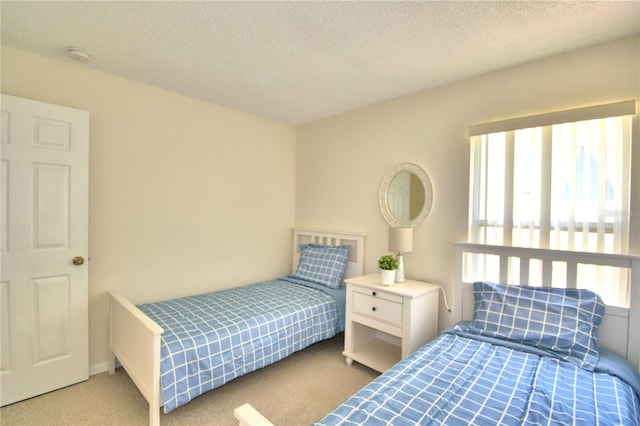 bedroom with light colored carpet and a textured ceiling