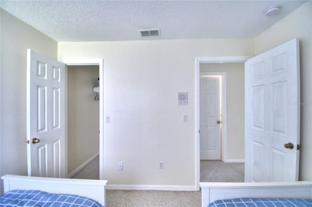 carpeted bedroom featuring a textured ceiling