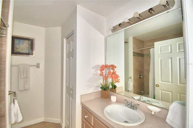 bathroom with hardwood / wood-style floors, vanity, and shower / bath combo