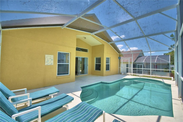 view of swimming pool featuring glass enclosure and a patio area