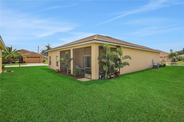 rear view of property featuring a lawn, a sunroom, and central air condition unit