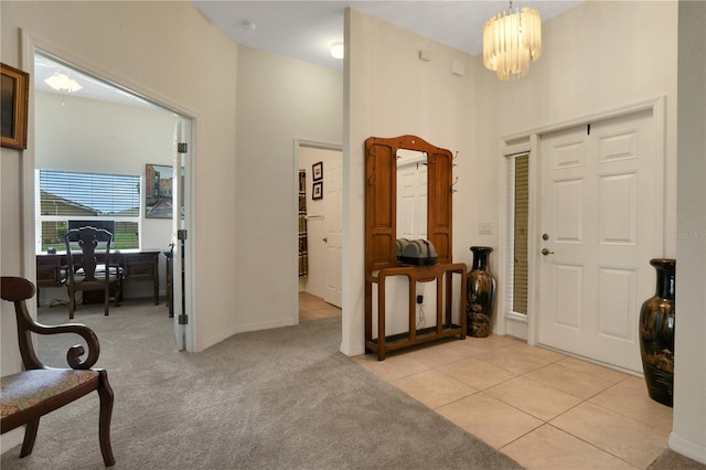 entryway featuring light carpet and a notable chandelier