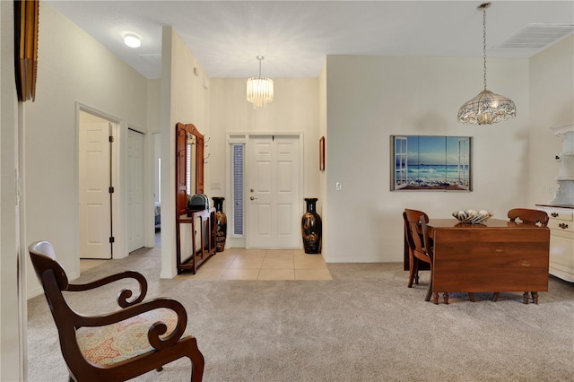 foyer featuring light colored carpet and a chandelier