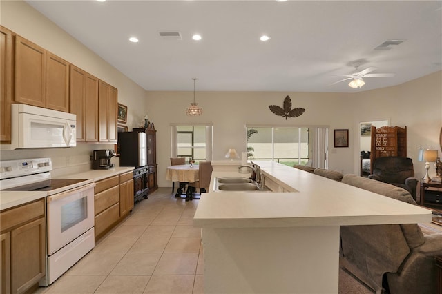 kitchen with white appliances, a kitchen island with sink, sink, pendant lighting, and light tile patterned flooring