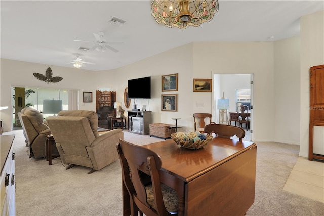 carpeted dining space featuring ceiling fan with notable chandelier