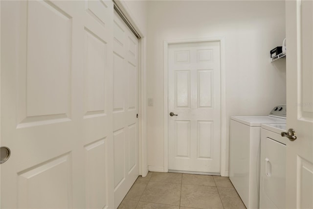 clothes washing area with light tile patterned floors and washing machine and dryer