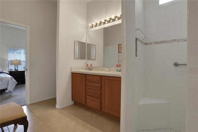 bathroom featuring tile patterned flooring, vanity, and tiled shower