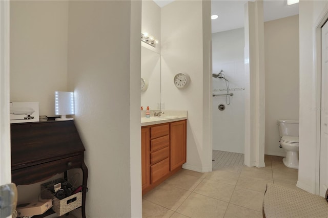 bathroom featuring tile patterned flooring, vanity, toilet, and a tile shower