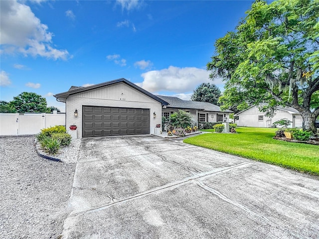 single story home featuring a front lawn and a garage