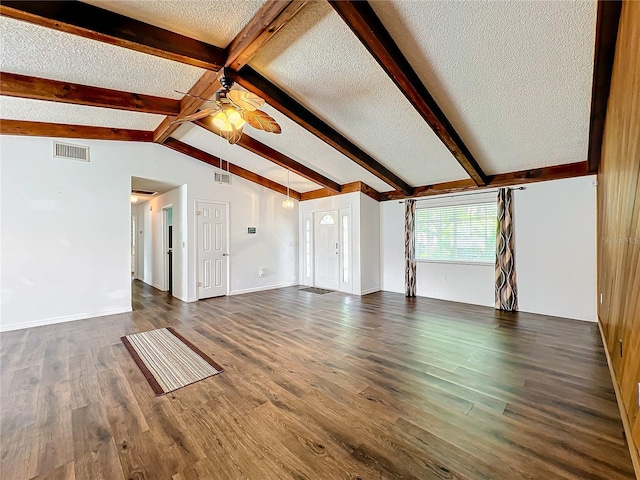 unfurnished living room featuring vaulted ceiling with beams, ceiling fan, dark wood-type flooring, and a textured ceiling