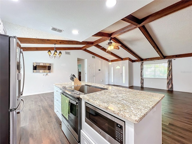 kitchen with stainless steel appliances, lofted ceiling with beams, a center island, dark hardwood / wood-style floors, and white cabinetry