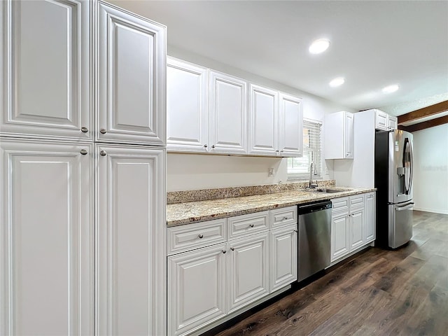 kitchen featuring sink, light stone counters, dark hardwood / wood-style flooring, white cabinets, and appliances with stainless steel finishes