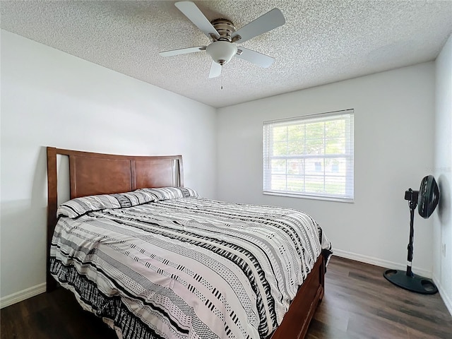 bedroom with ceiling fan, dark hardwood / wood-style flooring, and a textured ceiling