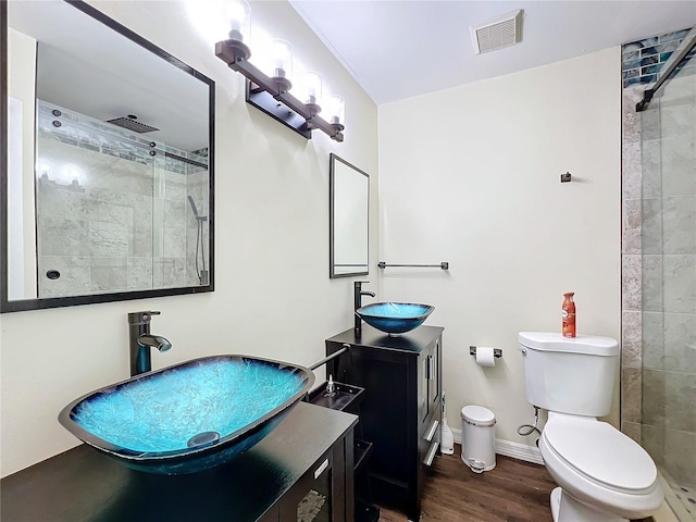 bathroom with a shower with shower door, toilet, wood-type flooring, and vanity