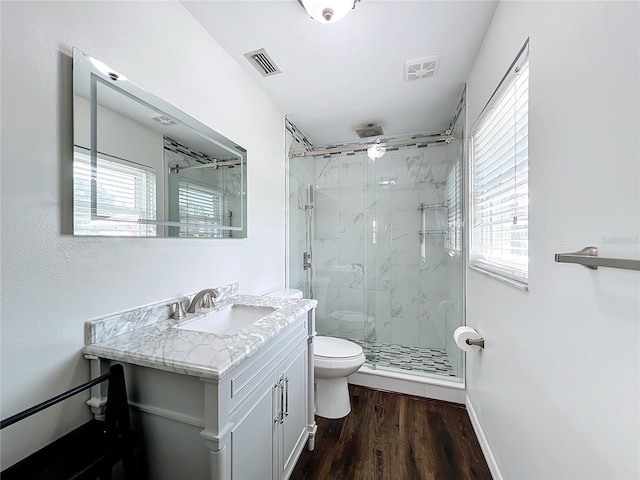 bathroom featuring vanity, toilet, wood-type flooring, and walk in shower