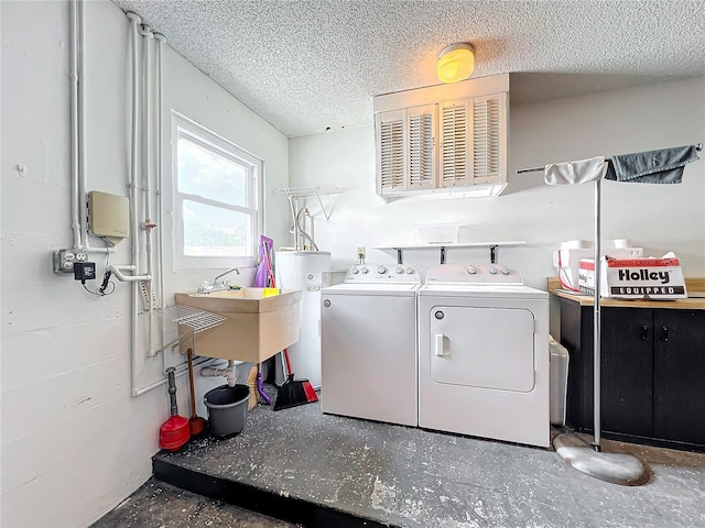 clothes washing area featuring independent washer and dryer, a textured ceiling, gas water heater, and sink