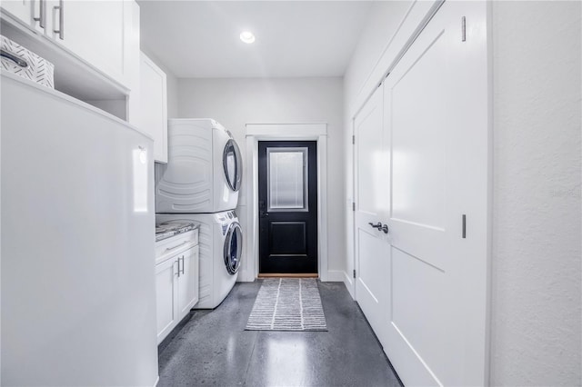 laundry room with stacked washer and dryer and cabinets