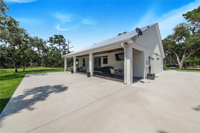 rear view of property featuring a patio and a yard