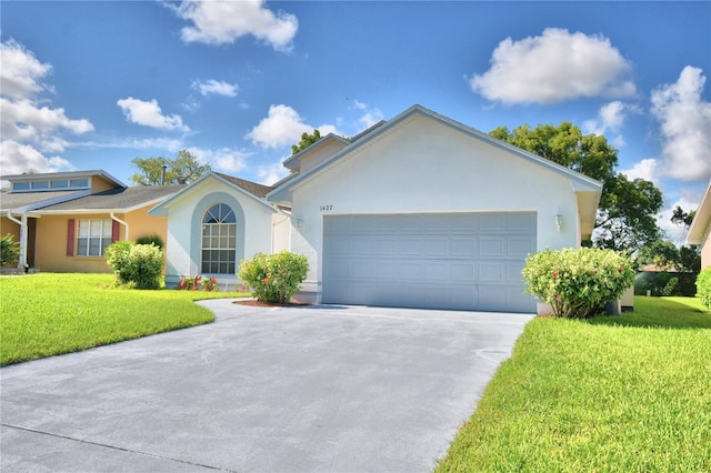 single story home featuring an attached garage, driveway, a front yard, and stucco siding