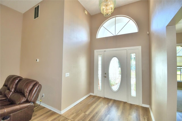 foyer entrance featuring a wealth of natural light, baseboards, visible vents, and light wood finished floors