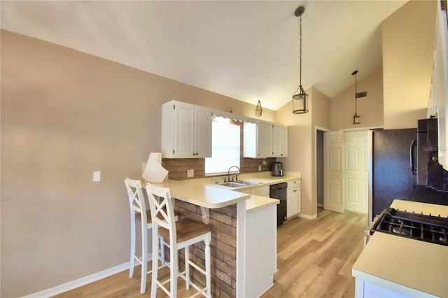 kitchen featuring light countertops, white cabinetry, hanging light fixtures, and dishwasher