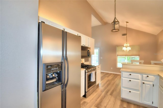 kitchen featuring white cabinets, appliances with stainless steel finishes, decorative light fixtures, light countertops, and light wood-type flooring