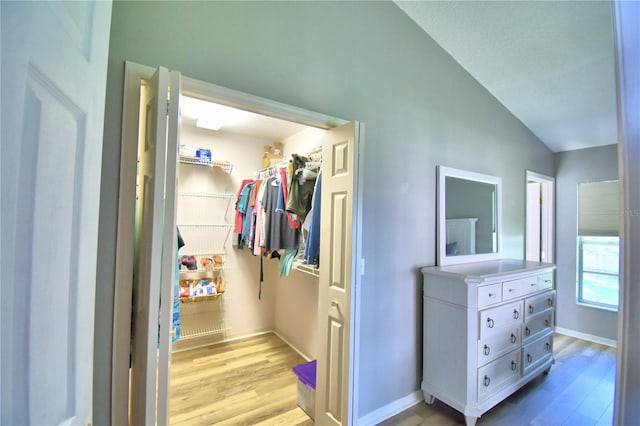 spacious closet featuring vaulted ceiling and light wood finished floors