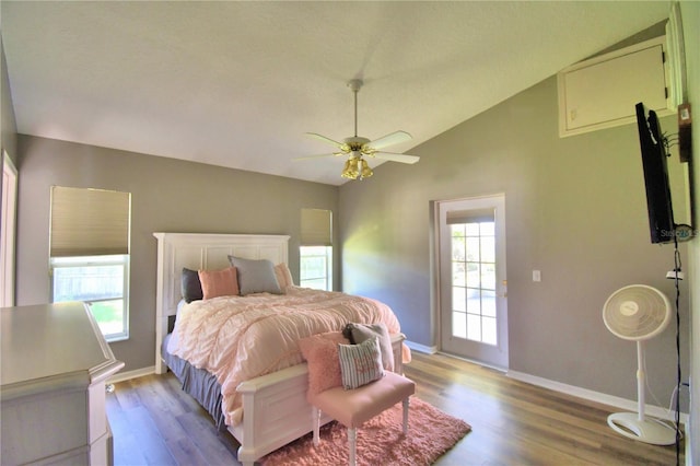 bedroom featuring light wood finished floors, ceiling fan, baseboards, and vaulted ceiling