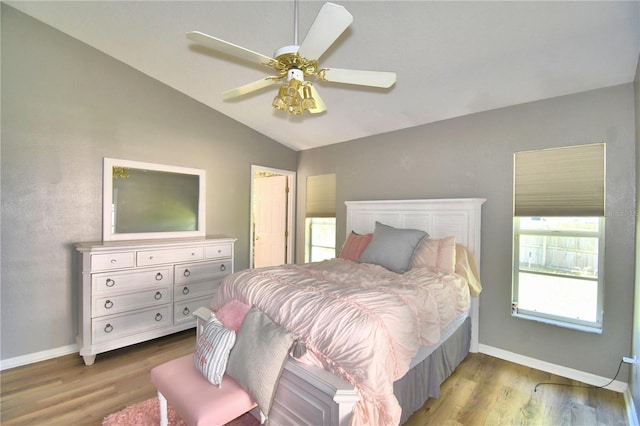 bedroom featuring vaulted ceiling, baseboards, and wood finished floors