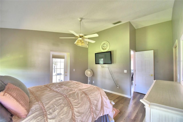 bedroom featuring lofted ceiling, a ceiling fan, visible vents, baseboards, and dark wood finished floors