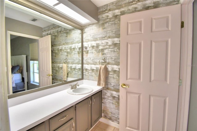 bathroom with wooden walls, a skylight, visible vents, and vanity