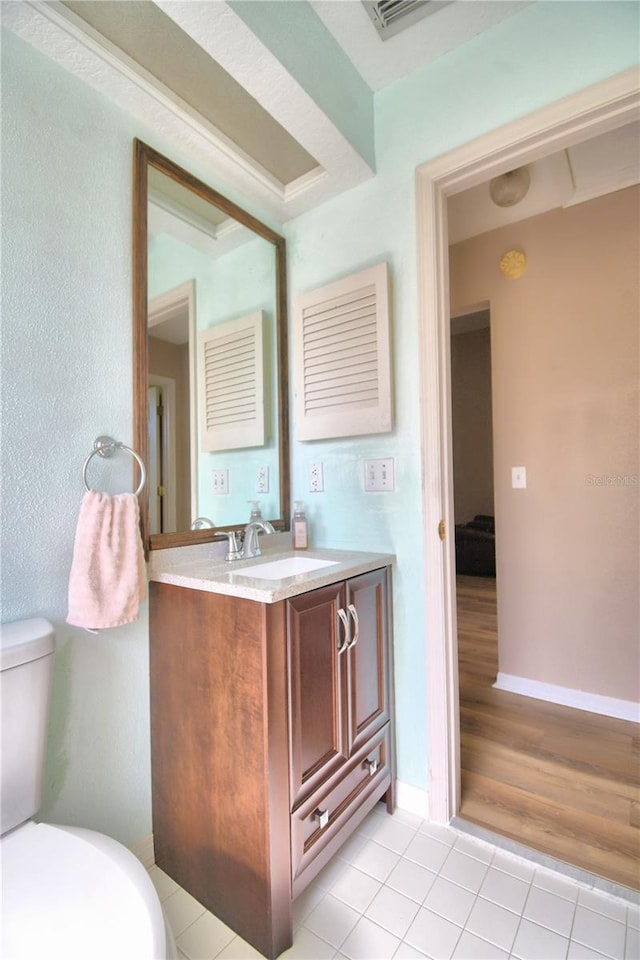 bathroom featuring vanity, tile patterned flooring, toilet, and baseboards