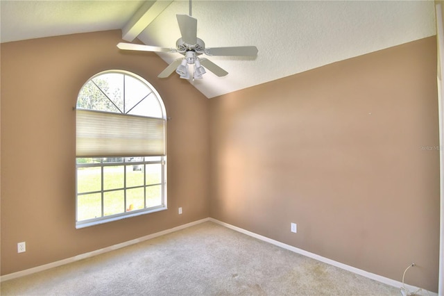 spare room with light colored carpet, lofted ceiling with beams, baseboards, and a textured ceiling