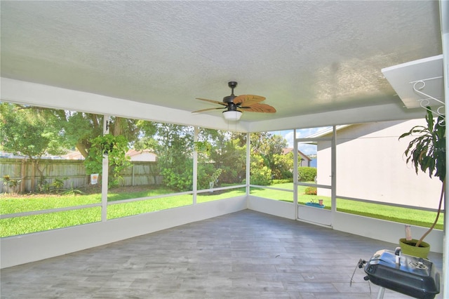 unfurnished sunroom featuring ceiling fan